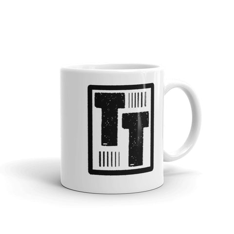 This is a ceramic mug offered by Tawdry Tees featuring the Tawdry Tees Logo.  It is a white mug with a black design.  Comfortable, sturdy and microwave and dishwasher safe.